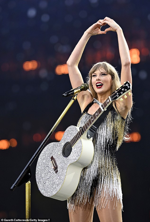 The singer forms a love heart with her hands as she addresses last night's crowd