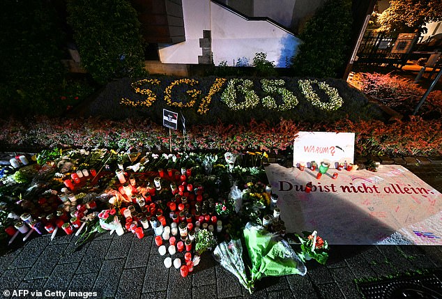 Candles and flowers and the inscription "Why? You are not alone" are pictured on late August 24, 2024 near the area where three people were killed and several injured