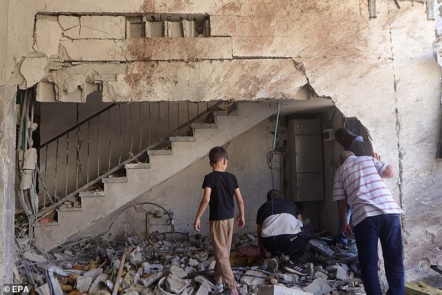 Palestinians inspect a damaged building in Tulkarem refugee camp