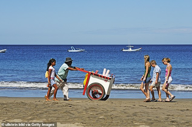 An iceman walks down the beach of Playa Hermosa in Costa Rica