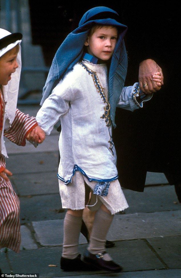 Harry, wearing a white embroidered tunic and a blue scarf on his head, ready for his nativity play in 1988