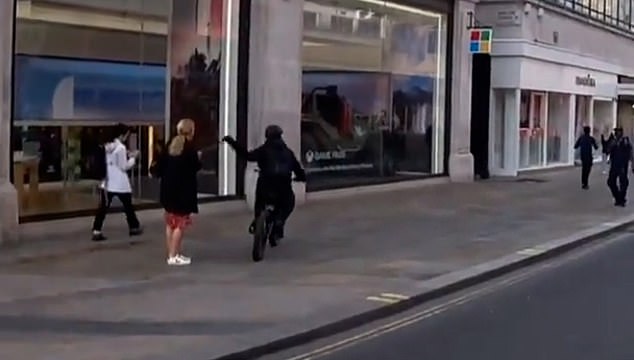 A woman can only look on, stunned, after an e-bike rider snatched a phone from her hand on Oxford Street