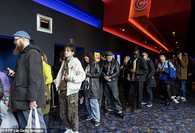 More spectators are seen lined up outside the theater on Wednesday for the premiere