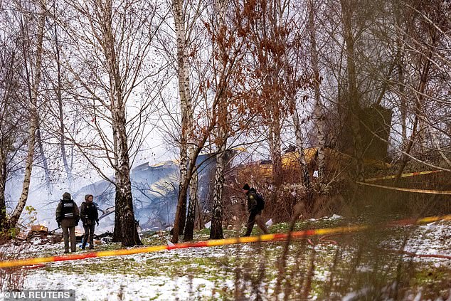 A cordon is seen around the affected area with plane wreckage visible among the trees