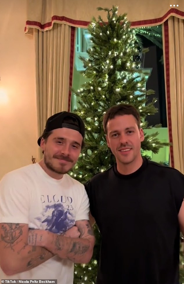 Brooklyn posed with Nicola's older brother Brad in front of her parents' Christmas tree