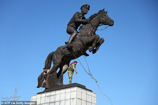 Anti-government fighters prepare to topple the equestrian statue of Bassel-al-Assad, the eldest son of late Syrian president Hafez al-Assad, who was killed in a car crash in 1994, in central Aleppo on November 30, 2024