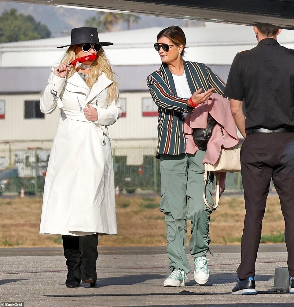 The Toxic hitmaker looked chic in a white trench coat paired with a plaid top and black knee-high boots