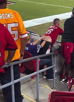 A female fan was caught rubbing a man's back and hips at an NFL game in a resurfaced video