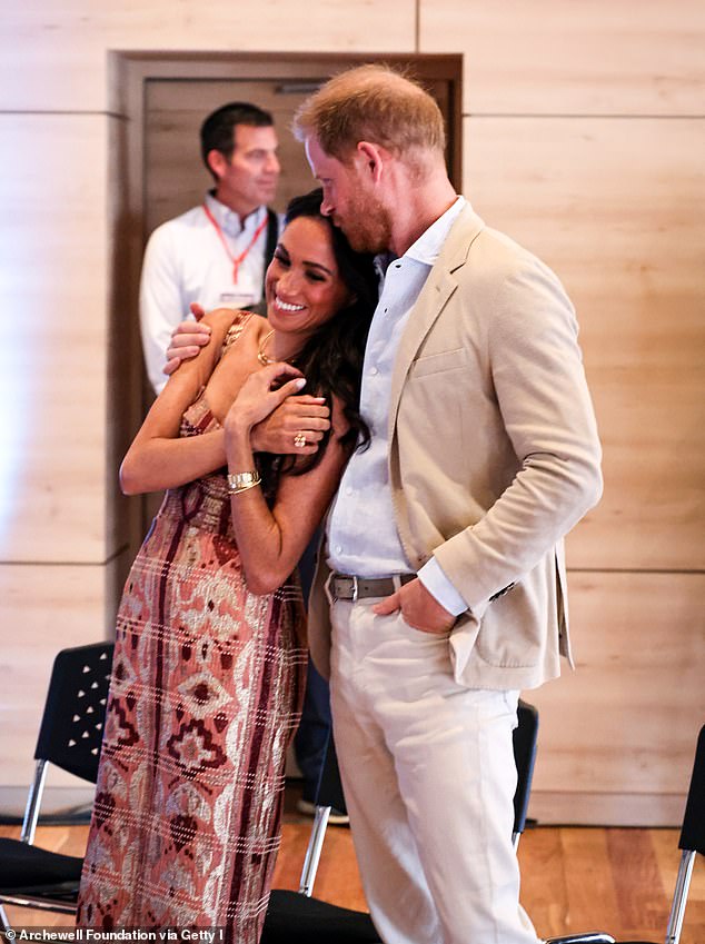 Another photo that appears in the Christmas card shows Prince Harry planting a kiss on Meghan's forehead in a photo taken during their four-day visit to Colombia in August