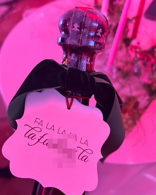 Her cheekily decorated champagne bottles featured tags that read 'fa la la la, fa la f***ing la'