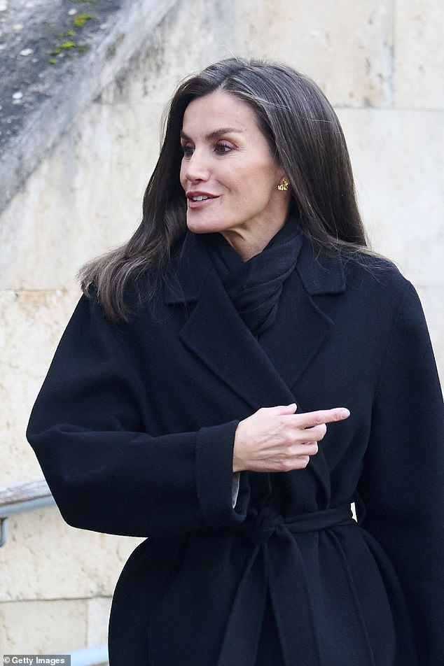 To combat the cold, the royal mother-of-two donned a knee-length black coat which was cinched in at the waist with a matching belt