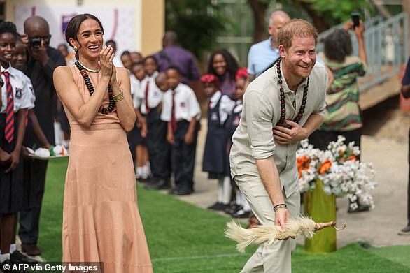 The couple's first public event in Nigeria was a visit to the Lightway Academy in Abuja, Nigeria's capital, and Meghan oozed casual elegance in the 'Windsor' silk gown from Californian designer Heidi Merrick