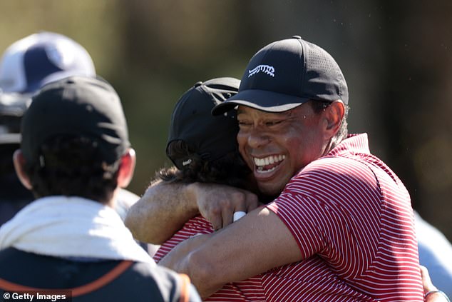 Tiger Woods bear hugs his son Charlie, 15, after the youngster fired in a hole-in-one