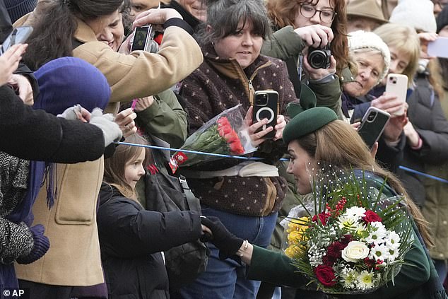 Kate, Princess of Wales shakes hands with a little girl as she greets members of the public after attending the Christmas day service at St Mary Magdalene Church in Sandringham in Norfolk