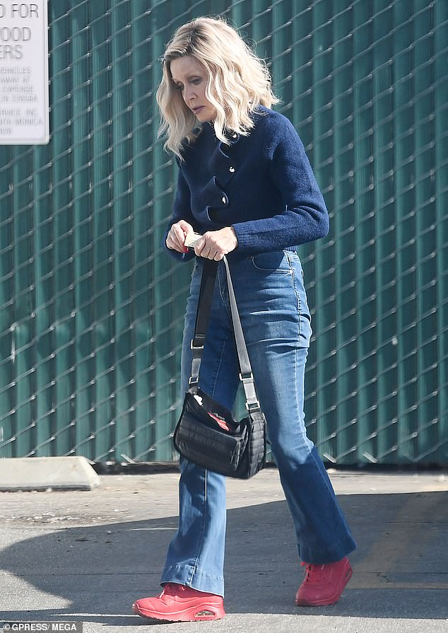 The Knot's Landing actress had on a blue sweater and nicely fitted blue denim jeans that showed off her slender figure. She added red sneakers