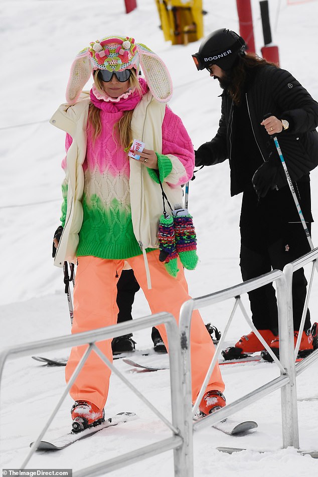 Heidi donned a pastel ombré cable-knit sweater paired with vibrant orange ski pants, but it was her quirky hat—complete with long bunny ears—that stole the show