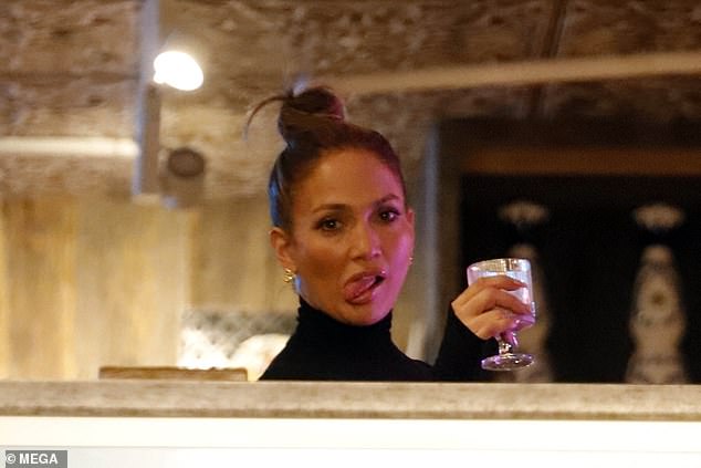 Jennifer seen making a silly face while unwinding with a drink