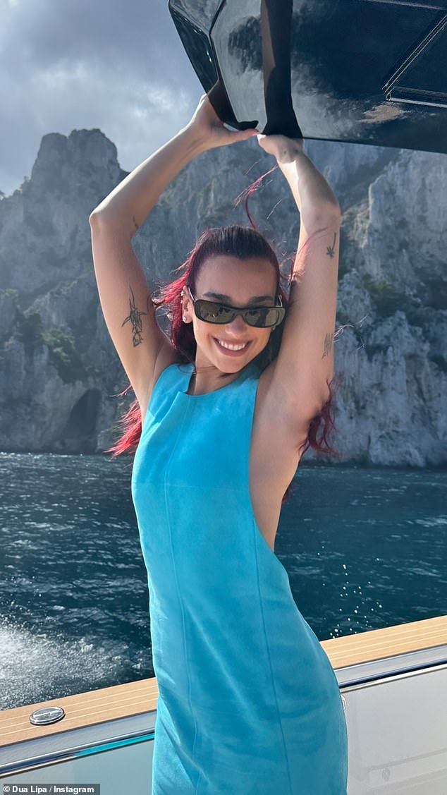 As well as the happy news, Dua continued to post a string of images of her time over the past year including this one on board a boat where she wore a mini blue dress