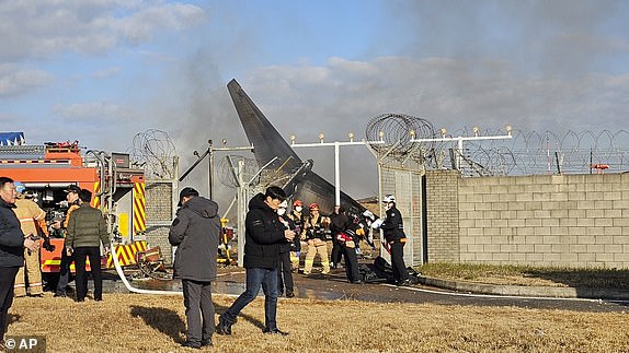 Firefighters and rescue team members work at the Muan International Airport in Muan, South Korea, Sunday, Dec. 29, 2024. (Maeng Dae-hwan/Newsis via AP)