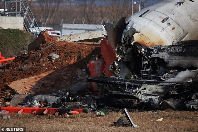 The wreckage of an aircraft lies on the ground after it went off the runway and crashed at Muan International Airport, in Muan, South Korea - December 29, 2024