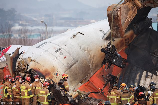 An excavator is used to lift burnt chairs from the wreckage  - December 29, 2024