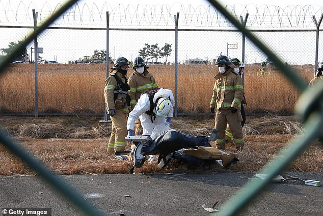 South Korean rescue team members check near the wreckage