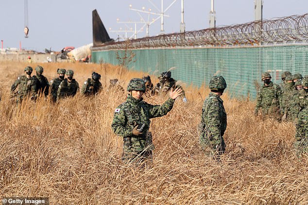 South Korean soldiers check near the wreckage of a passenger plane at Muan International Airport