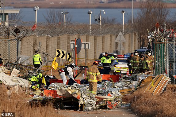 epa11797036 Firefighters search at the wreckage of the Jeju Air aircraft at Muan International Airport in Muan, 288 kilometers southwest of Seoul, South Korea, 29 December 2024. According to the National Fire Agency, a passenger jet carrying 181 people erupted in flames after going off the runway at an airport in South Korea's southwestern county of Muan on 29 December, leaving at least 176 people dead.  EPA/HAN MYUNG-GU