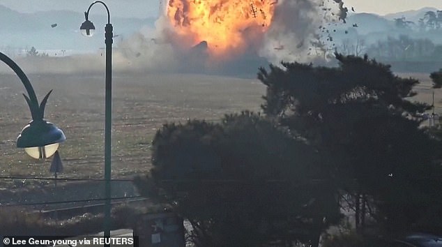 Jeju Air flight 7C2216 seen engulfed in flames as it slams into a wall following a crash after landing at Muan International Airport in Muan, South Korea