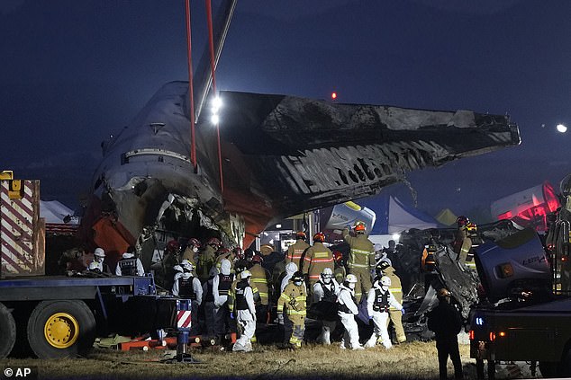 Rescue team carry the body of a passenger at the site of a plane fire at Muan International Airport in Muan, South Korea