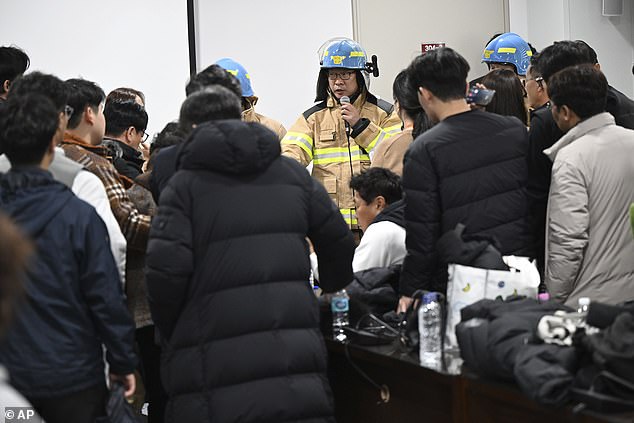 An official from fire station briefs to the family members of the passengers on a plane which burst into flames, at the Muan International Airport in Muan, South Korea