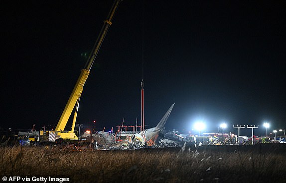 Firefighters and rescue personnel work near the scene where a Jeju Air Boeing 737-800 series aircraft crashed and burst into flames at Muan International Airport in South Jeolla Province, some 288 kilometres southwest of Seoul on December 29, 2024. A Jeju Air plane carrying 181 people from Thailand to South Korea crashed on arrival, smashing into a barrier and bursting into flames, leaving all but two feared dead. (Photo by Jung Yeon-je / AFP) (Photo by JUNG YEON-JE/AFP via Getty Images)