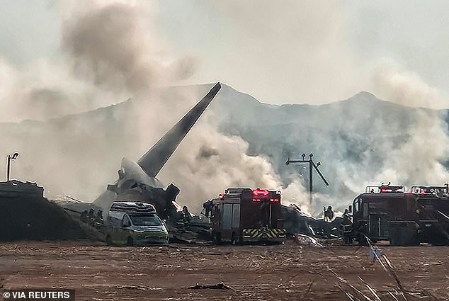 Firefighters attempt to extinguish the flames after the jet burst into flames after ploughing into a concrete wall