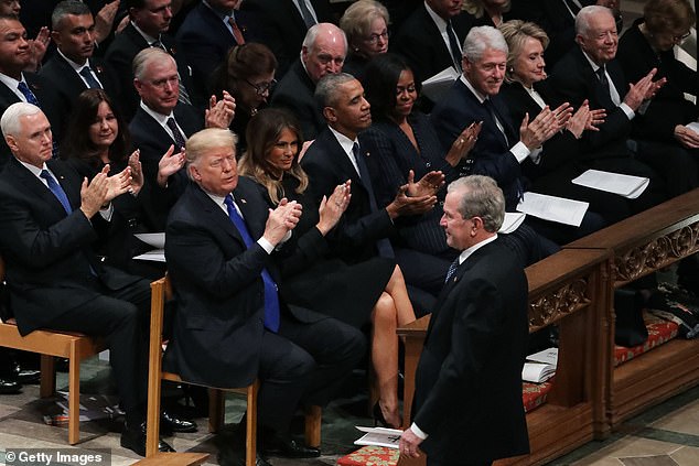 The four other living presidents are younger than Biden including former President Donald Trump (front row, left), George W. Bush (right, standing), Barack Obama (third from left) and Bill Clinton (third from right)