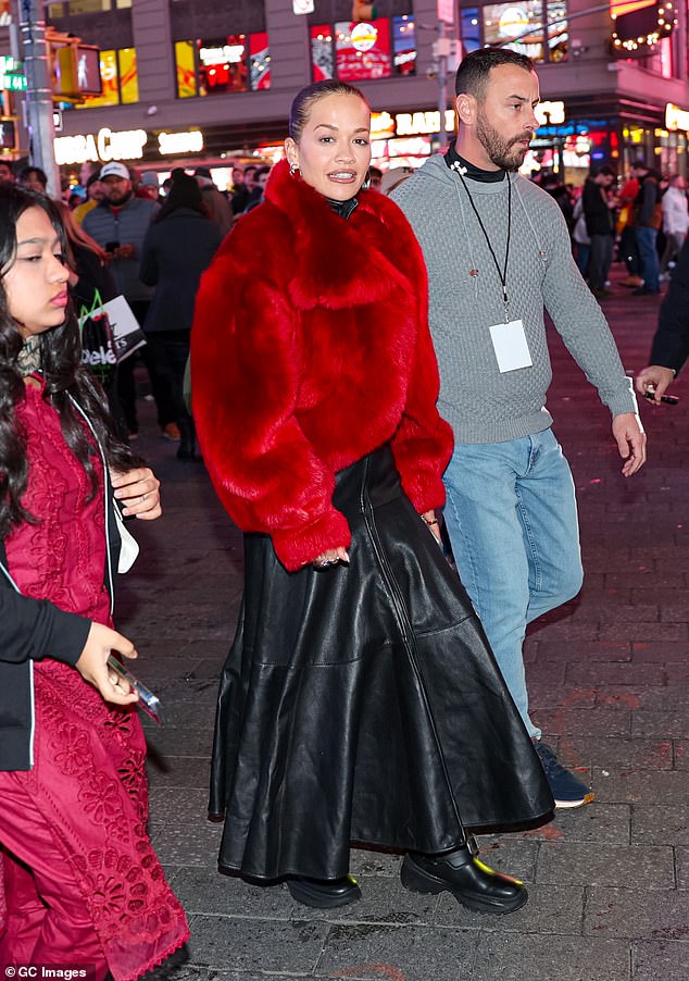 The singer, 34, layered her statement piece over a black leather dress as she helped out Ryan Seacrest with the annual show's hosting duties