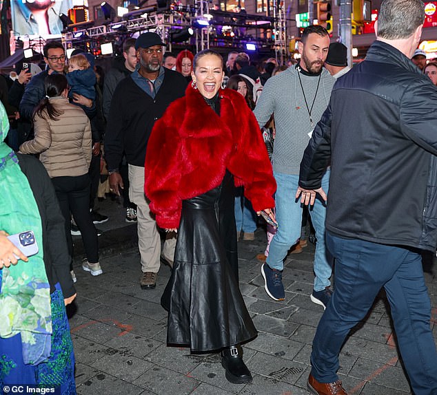 Her floor-length garment featured a full-length zip, a high neckline, and a flowing skirt