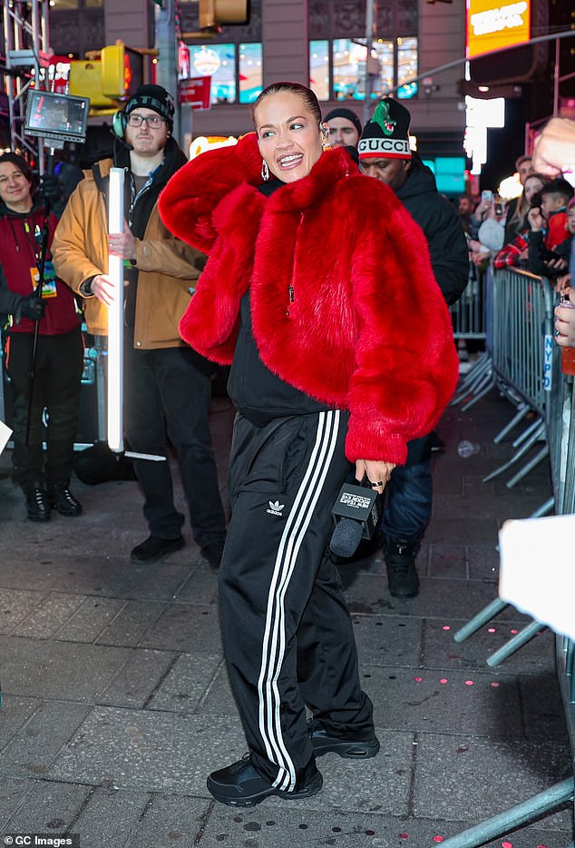 She paired her relaxed trousers with a matching zip-up jacket and a pair of black trainers