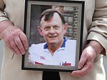 Bridie Brown, the widow of murdered GAA official Sean Brown, holds a picture of him (PA)