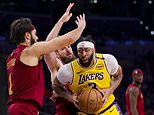 Los Angeles Lakers forward Anthony Davis, frint right, drives against Cleveland Cavaliers guard Max Strus, left, and forward Dean Wade, center, during the second half of an NBA basketball game Tuesday, Dec. 31, 2024, in Los Angeles. (AP Photo/Ryan Sun)