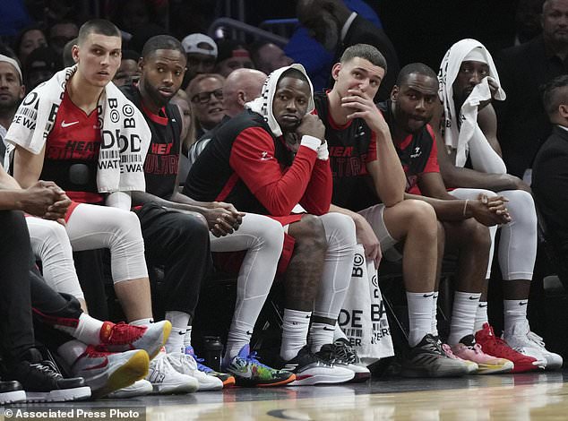 Miami Heat guard Tyler Herro, left, and center Bam Adebayo, far right, watch from the bench during the second half of an NBA basketball game against the Utah Jazz, Saturday, Jan. 4, 2025, in Miami. (AP Photo/Lynne Sladky)