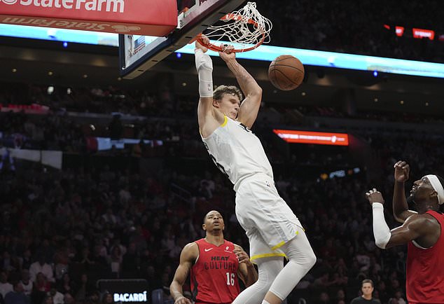 Utah Jazz forward Lauri Markkanen dunks over Miami Heat forward Kesha Johnson (16) and center Bam Adebayo, right, during the second half of an NBA basketball game Saturday, Jan. 4, 2025, in Miami. (AP Photo/Lynne Sladky)