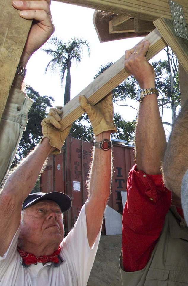 FILE - Former U.S. President Jimmy Carter helps in the contruction of a low-income housing project in Durban, South Africa, June 6, 2002. Carter was among 4,500 volunteers, organized by Habitat for Humanity, building 100 homes in the coastal city during the week. (AP Photo/Themba Hadebe, File)