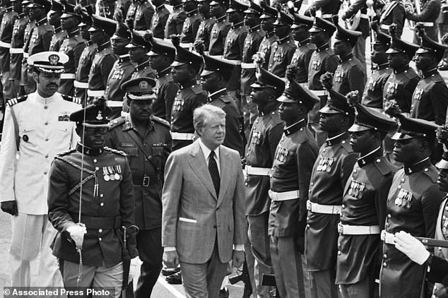 FILE - U.S. President Jimmy Carter reviews honor guards during arrival ceremonies at the Dodan Barracks in Lagos, Nigeria, April 1, 1978. (AP Photo, File)