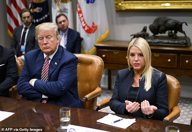 President Donald Trump (L) watches as Florida Attorney General Pam Bondi speaks during a meeting with state and local officials on school safety in the Roosevelt Room of the White House on February 22, 2018 in Washington, D.C.