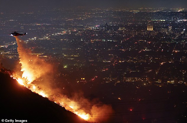 A firefighting helicopter dropped water in the Hollywood Hills on January 8 in LA