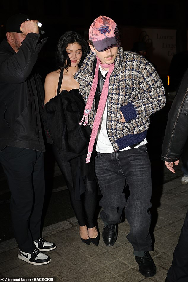 Jenner deployed her trademark pout and clung to her boyfriend's arm as they braved the thicket of paparazzi who just happened to be on hand to memorialize the 'romantic' evening in Paris.