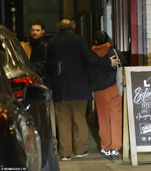 Jonny placed a hand on Aaliyah's back as they made their way inside alongside Charlie