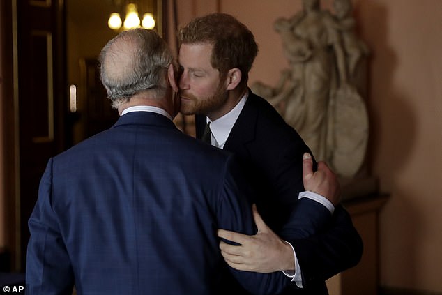 Prince Harry kisses and greets his father Prince Charles upon their separate arrival to attend a coral reef health and resilience meeting in London in 2018