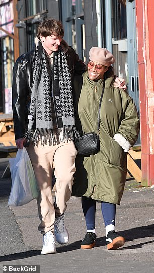 Alison wrapped up for the cold weather in a long green padded trench coat paired with navy sports leggings and trainers