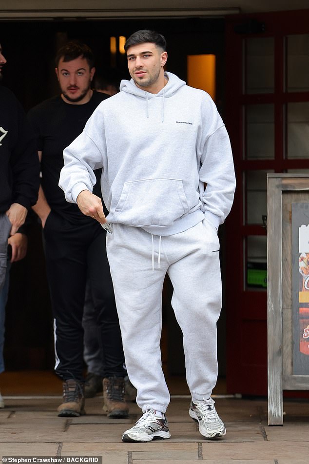 Tommy cut a laid-back figure, wearing a casual grey hoodie and matching jogging bottoms